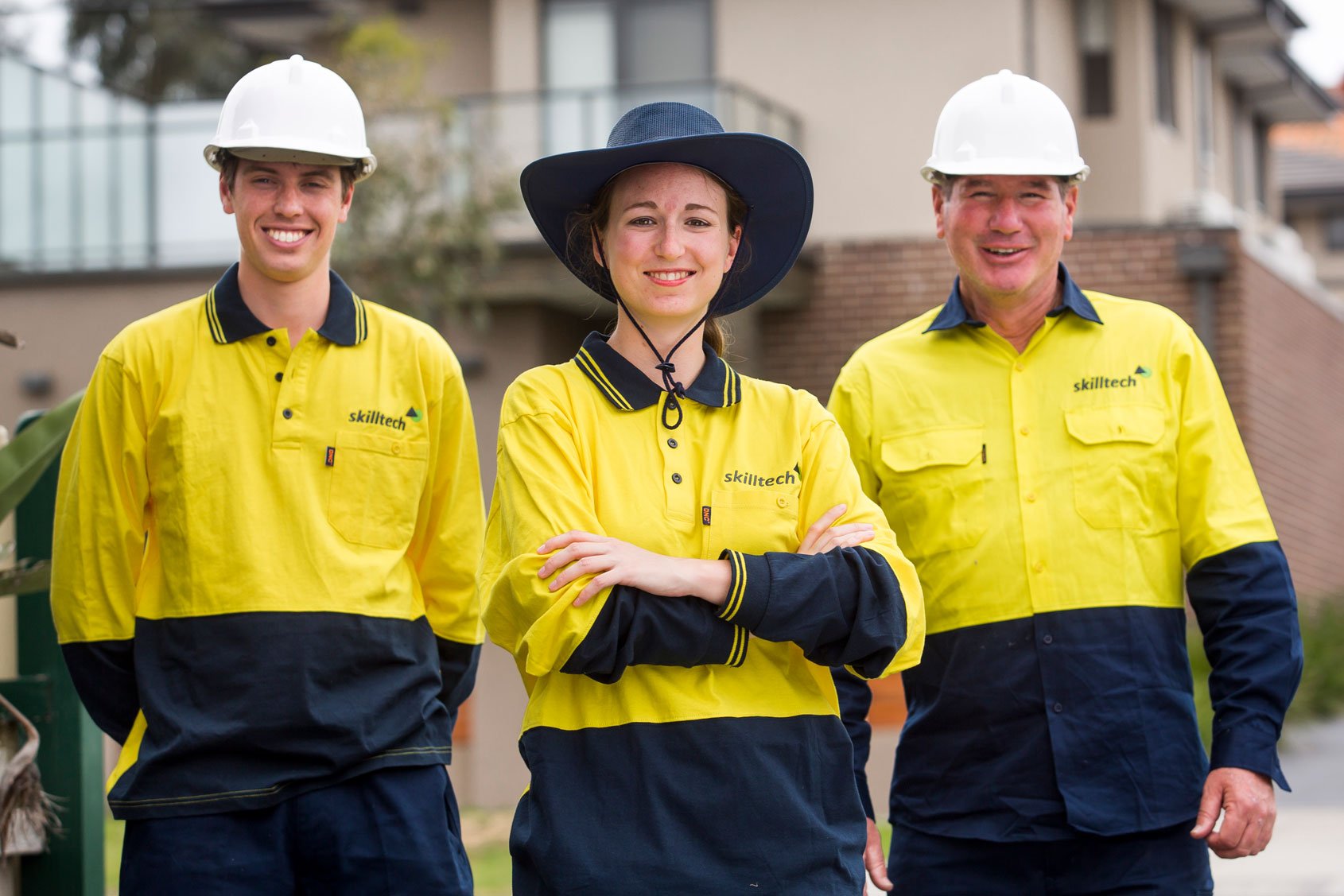 Three Skilltech meter readers in their uniform stood in front or a residential house