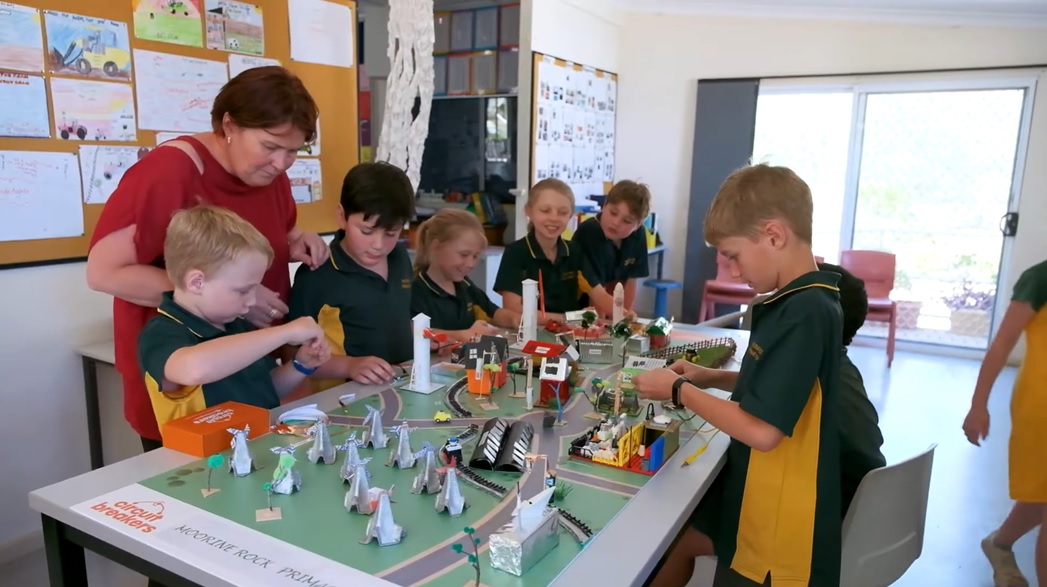 Primary school students building a model city with circuits and renewable energy as part of a hands-on electrical STEM education activity.