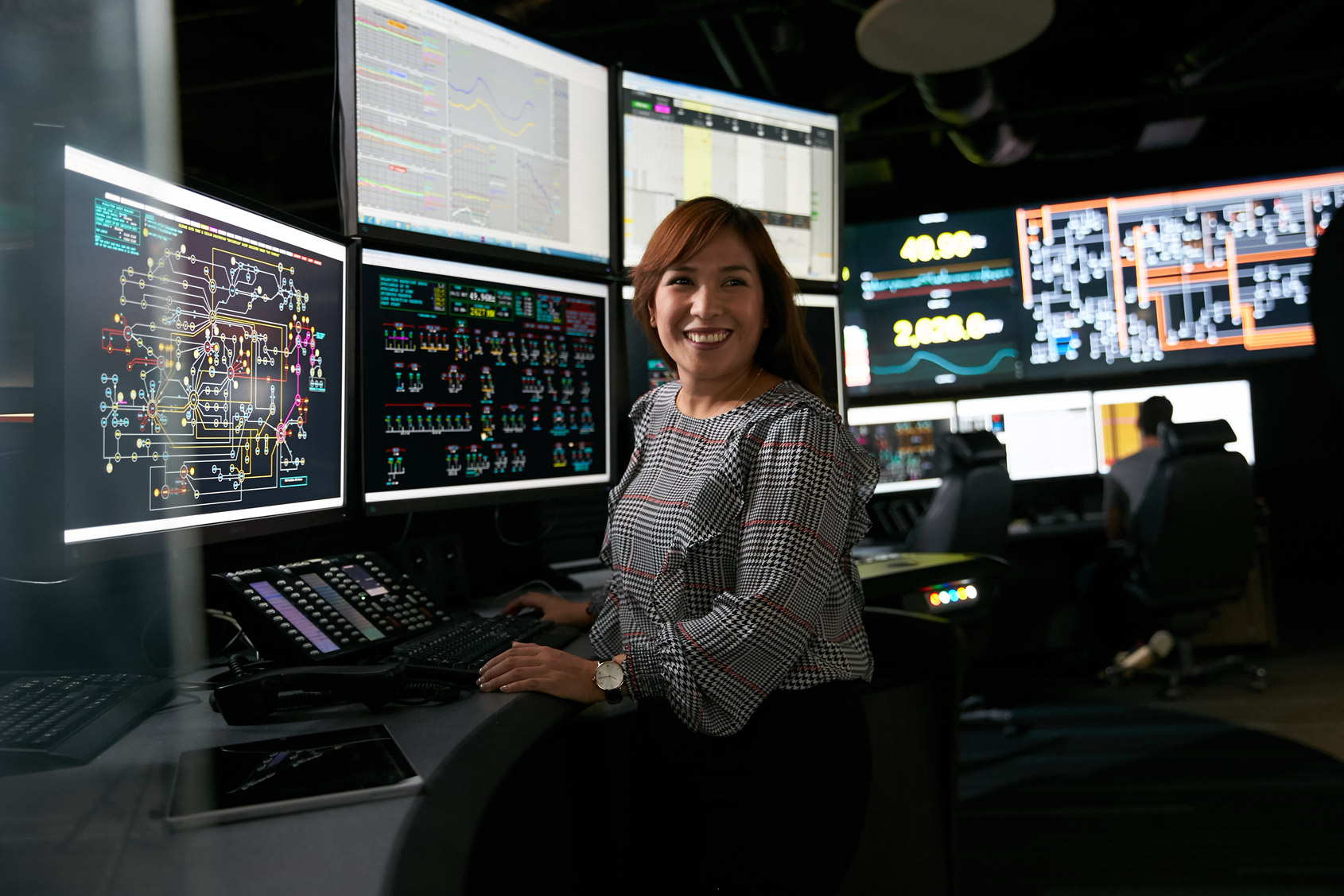 A Western Power employee sat in the Network Operations Centre with a range of screens in front of him displaying network information