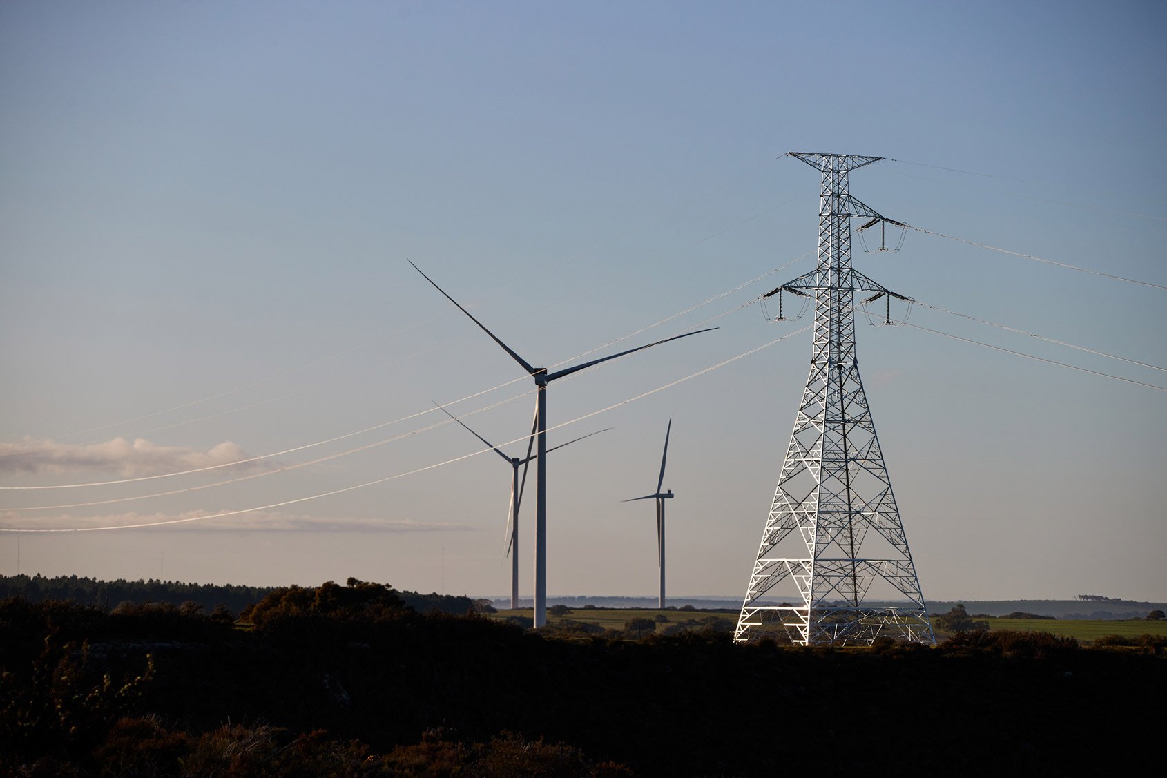 A single circuit lattice electricity tower connecting to a wind farm