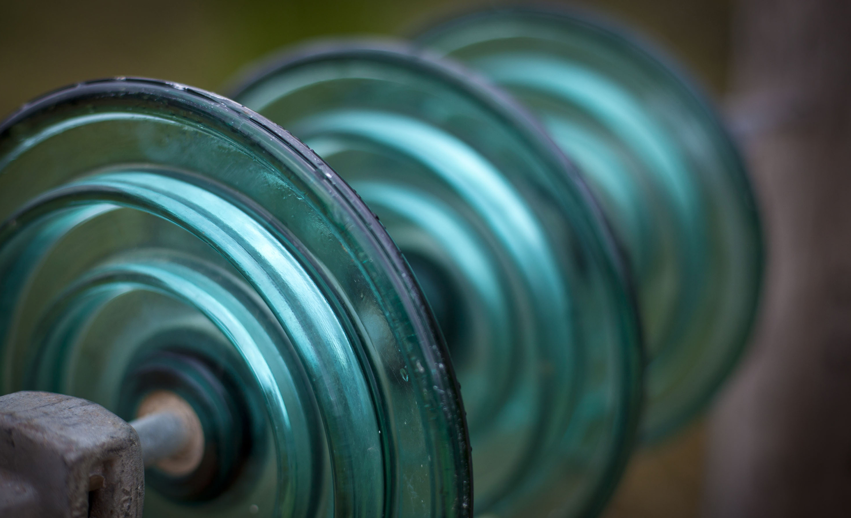 Close-up of green glass electrical insulators in a row.