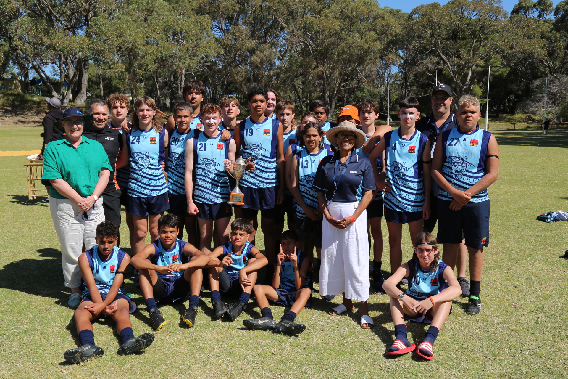 Team photo of Clontarf football team with trophy on a football oval.