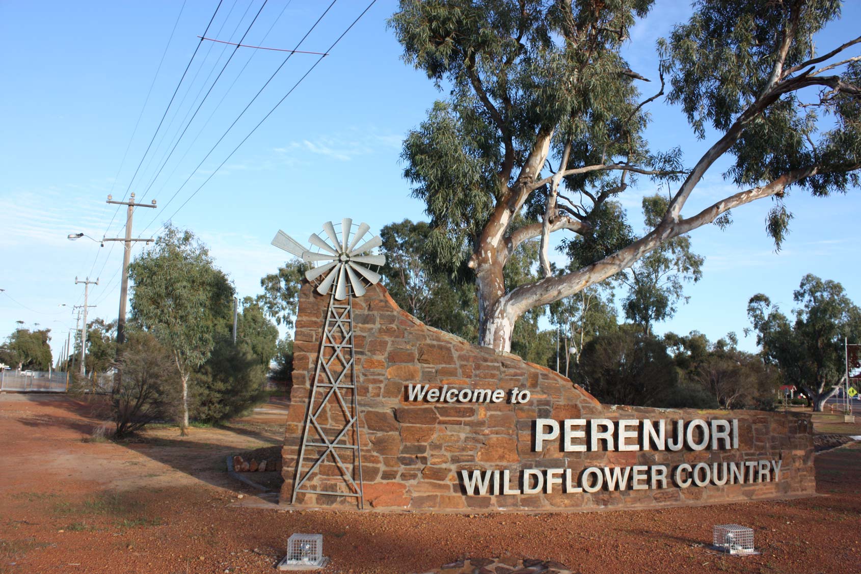 Stone welcome sign with a windmill reading ‘Welcome to Perenjori – Wildflower Country.