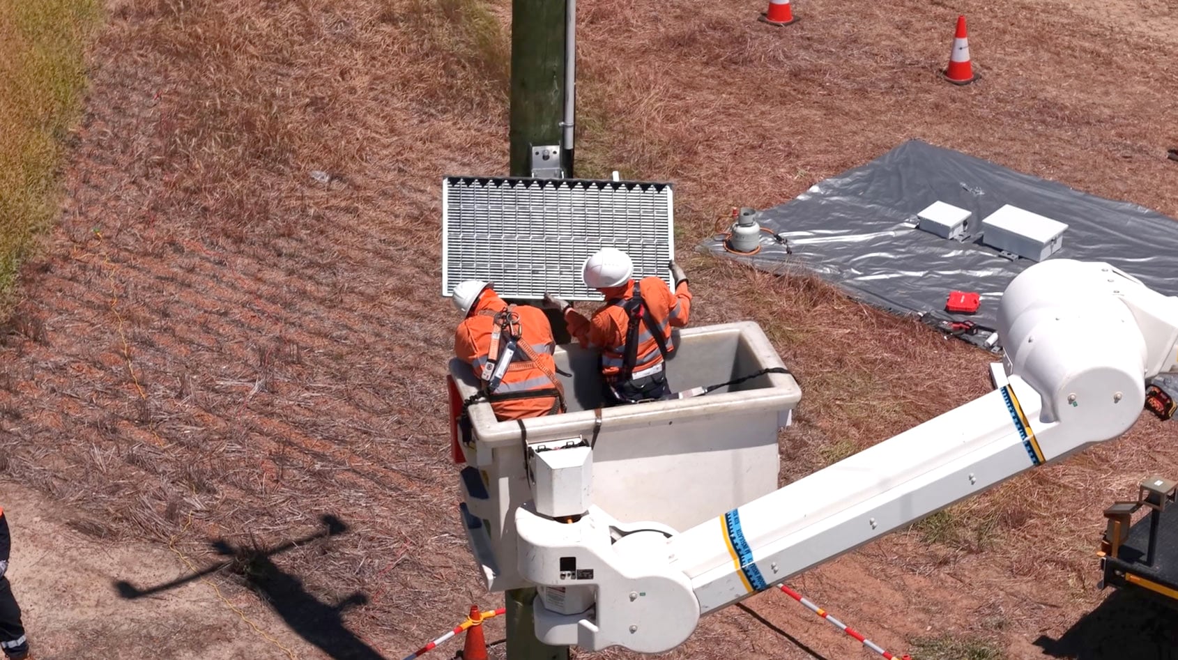 An Early Fault Detection unit been installed on an electricity pole but Western Power crew in an elevated bucket lift