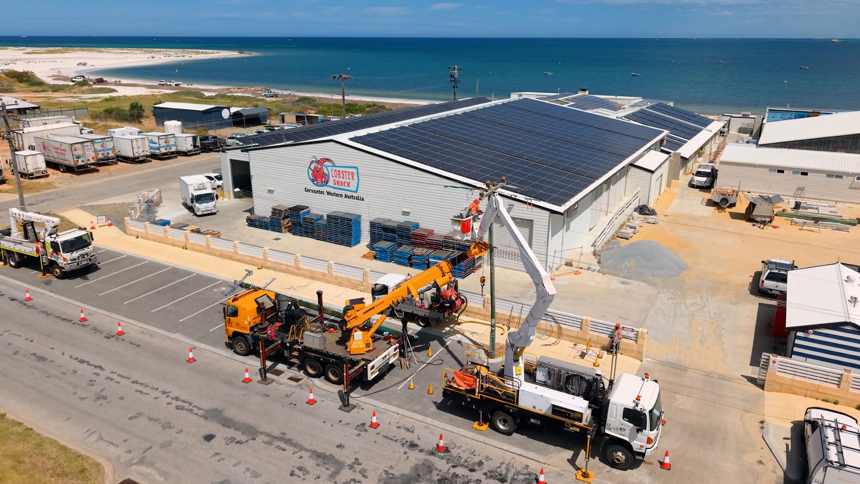 Aerial view of Western Power crews working on an power pole outside the Lobster Shack