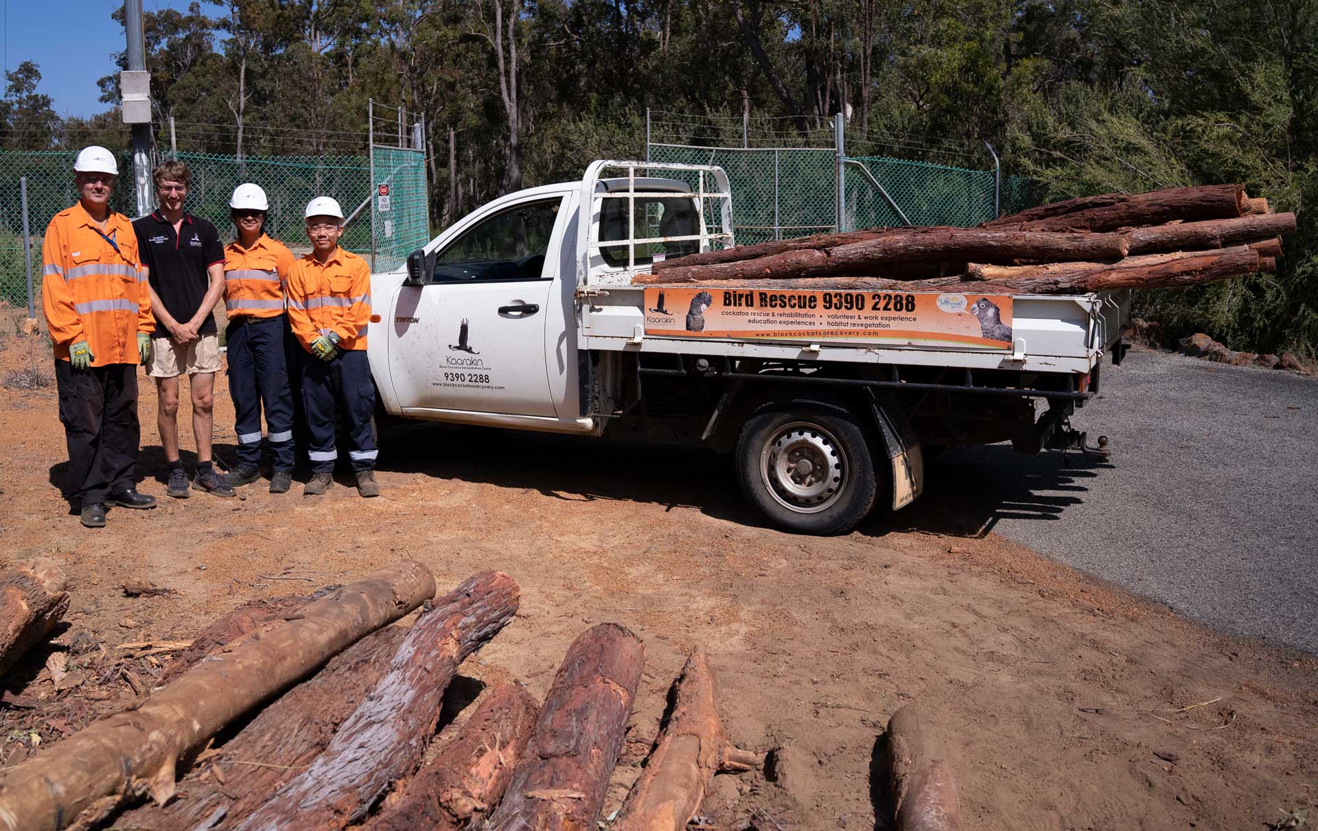 Western Power crew and a representative from the Kaarakin Black Cockatoo Conservation Centre stood in front of a ute carrying trees and branches