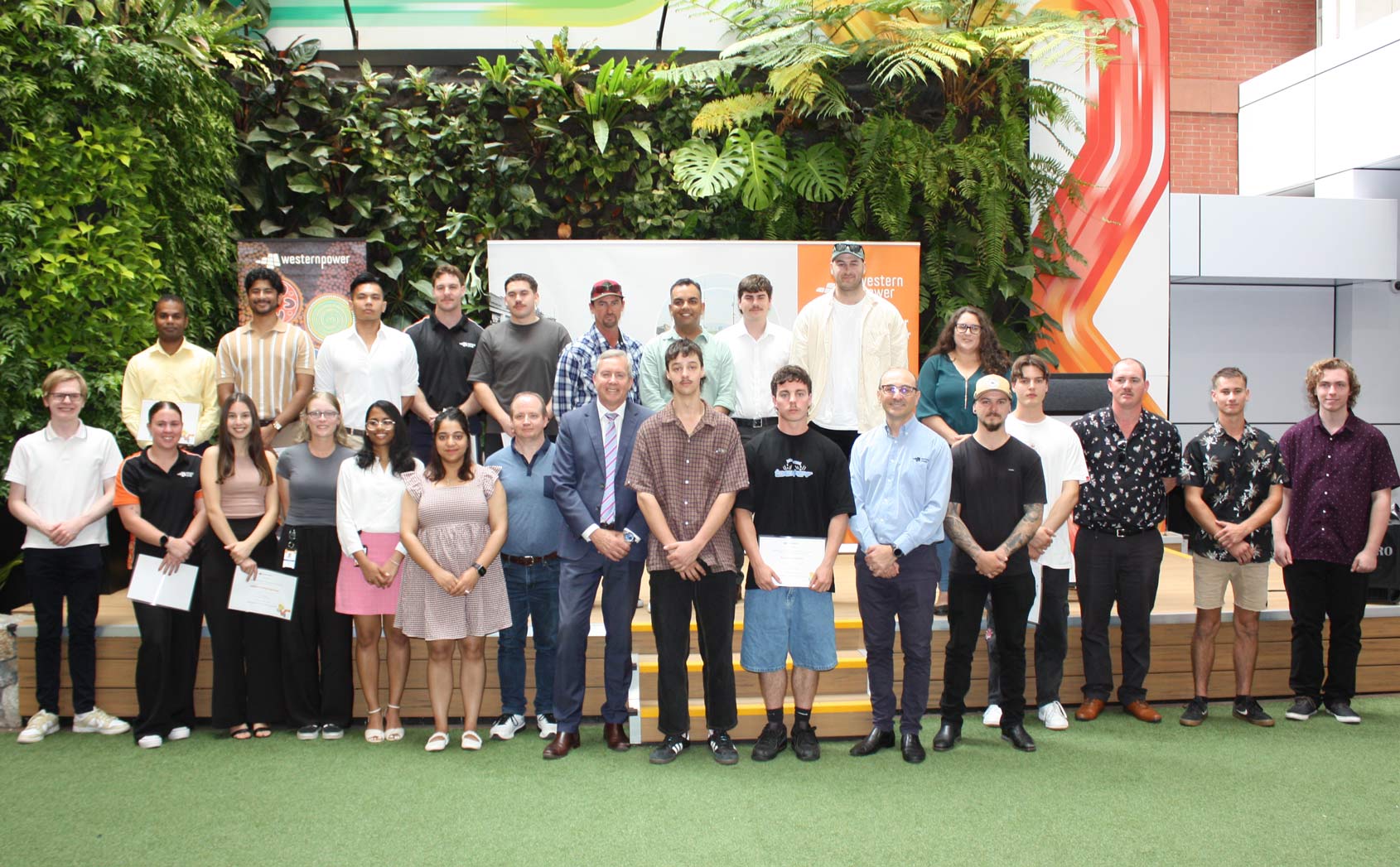 Western Power apprentices, trainees, and recent university graduates stood together with their certificates alongside Energy Minister Reece Whitby and CEO, Sam Barbaro