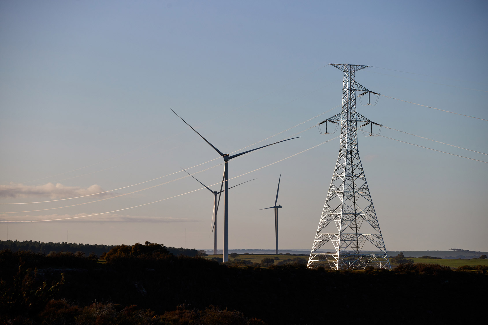 A single circuit lattice electricity tower connecting to a wind farm