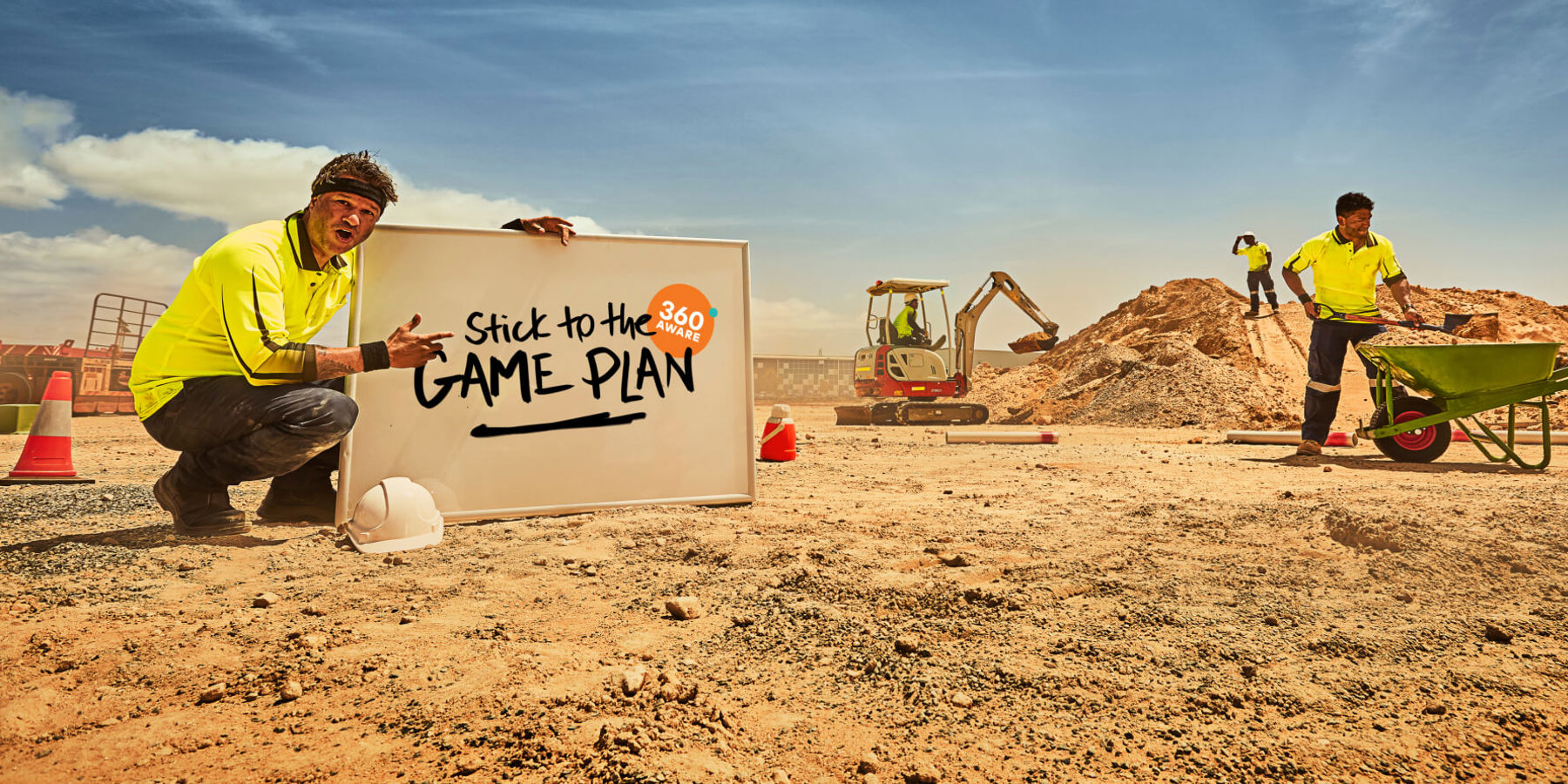 A construction worker on a building site holding a whiteboard with "Stick to the game plan" written on it.